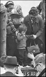 A young evacuee, looking very scared, is helped off a U.S. Army flatbed truck on the UA campus.