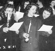 The chorus members at the graveside of tradition using beer bottles for candle holders. Photo: Rasmuson Library, Henry Kaiser Collection, Alaska Airlines