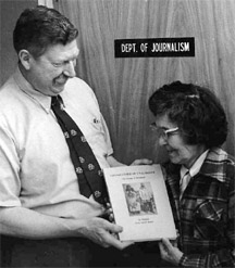 Jimmy Bedford and Emily Brown outside the UAF journalism office pose with Emily's new book, "Grandfather of Unalaklett."