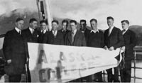 It shows the College basketball team in 1927 or 1928 on their trip to Southern Alaska. It looks like Ketchikan. Reading from left to right: Pres. Charles E. Bunnell (who finaced the trip), George Lingo, Donald McDonald III, John C, Jack Boswell, Richard "Bus" Boyd, Richard Anderson, Art Loftus, Verne B "Rusty" Reed, "Ted" Theadore A. Loftus, Coach Kenneth Abel. Photo: Rasmuson Library, Alaska and Polar Regions Collections