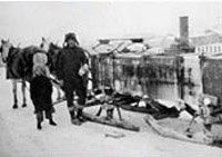 Pictured is the process of water delivery in the 1930s. A stove is used to keep the water from freezing. Photo: UAF Archives, LarVern Keys Collection
